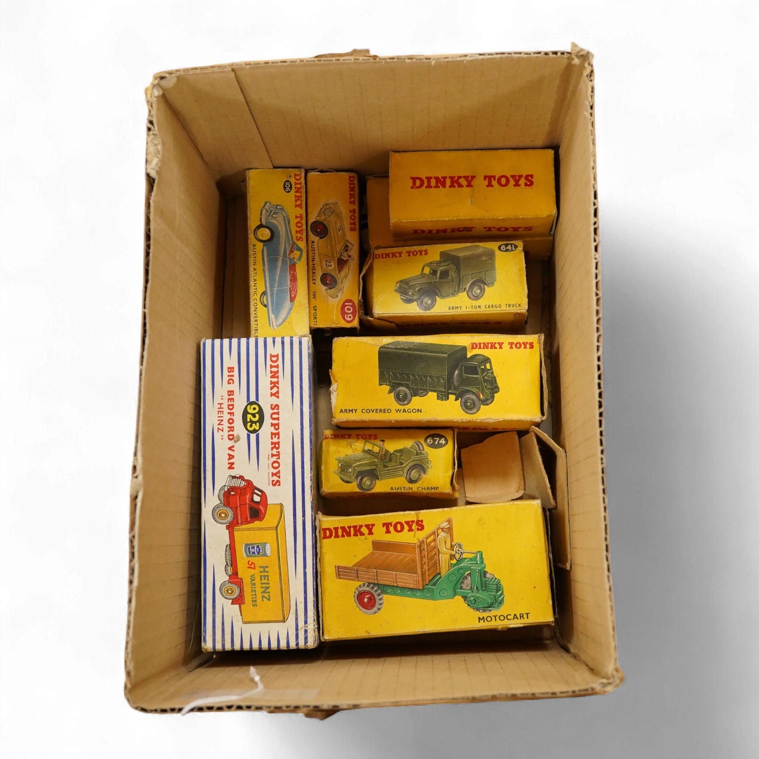 Nine Dinky Toys; Big Bedford Heinz van (923), Austin Atlantic Convertible (106), Austin-Healey 100 (109), M.G. Midget (108), Cunningham C-5R (133), Motocart (342), Austin Champ (674), Army Covered Wagon (623), and Army 1
